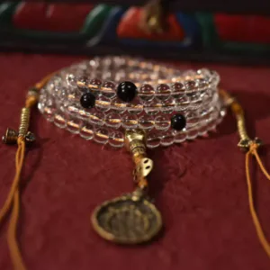 108-bead clear quartz mala with obsidian spacers and brass charm
