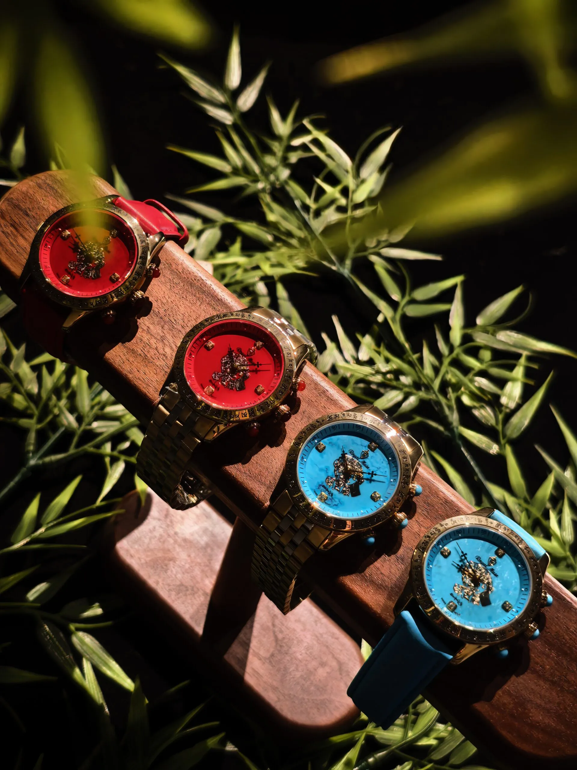 Three Royal Muse gemstone watches in red, turquoise blue and burgundy on a dark botanical background